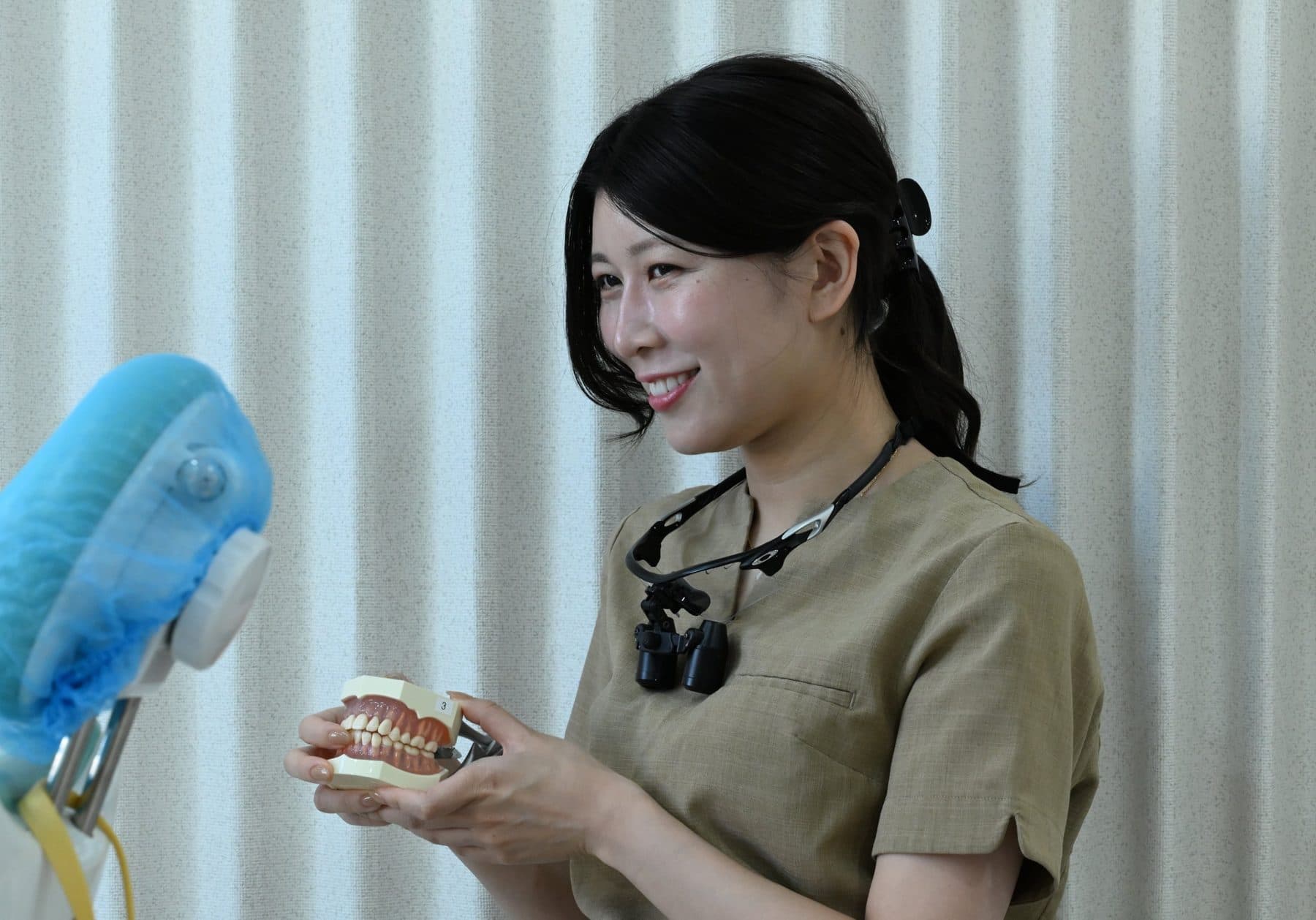 歯の模型を手に説明する歯科医師