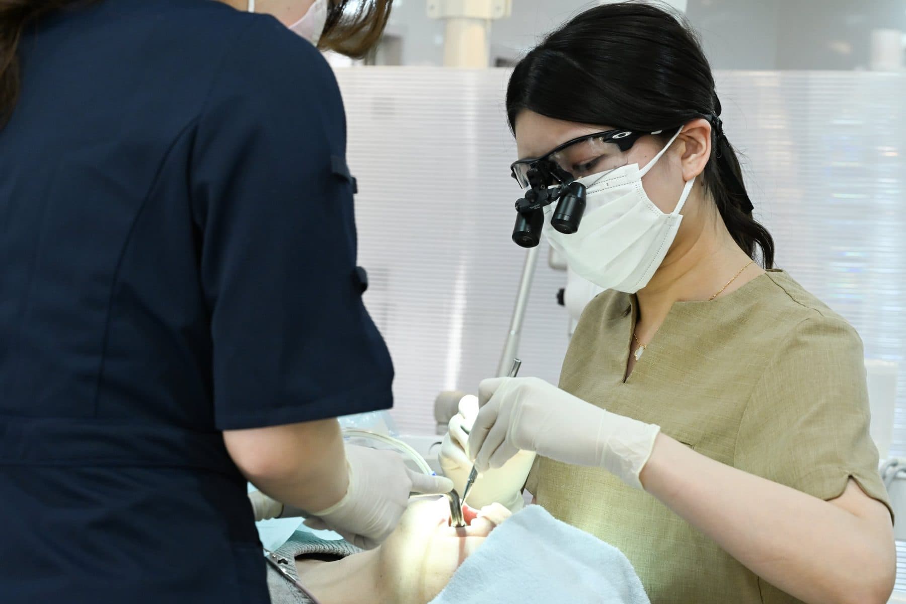 拡大鏡(ルーペ)を使って処置する歯科医師
